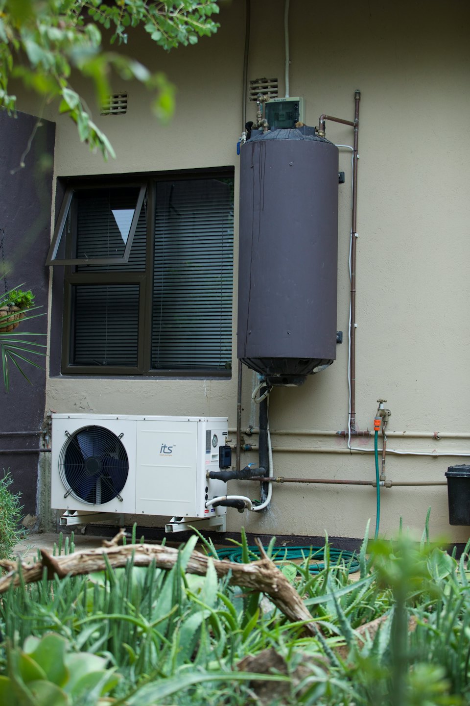 Moderner Warmwasserbereiter und Geyser an einer Außenwand eines Gebäudes.
