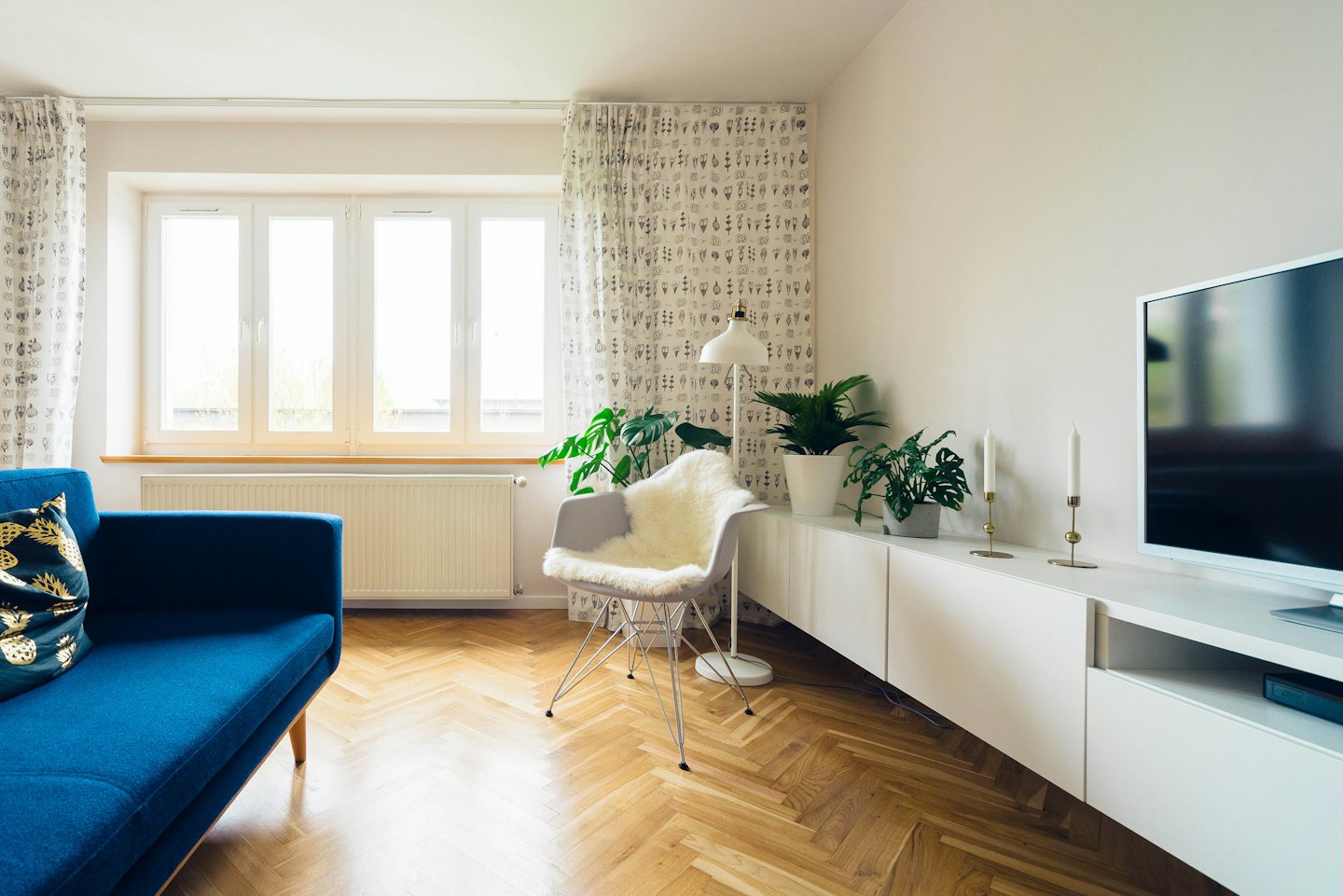 Modernes Wohnzimmer mit blauem Sofa und wei&szlig;em Sessel.